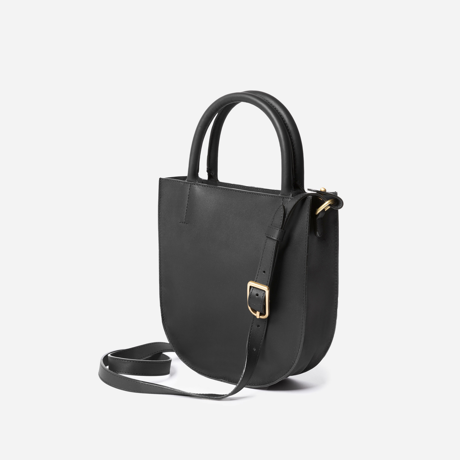 A black leather crossbody bag with an adjustable strap and solid brass hardware, viewed from the front. - Black