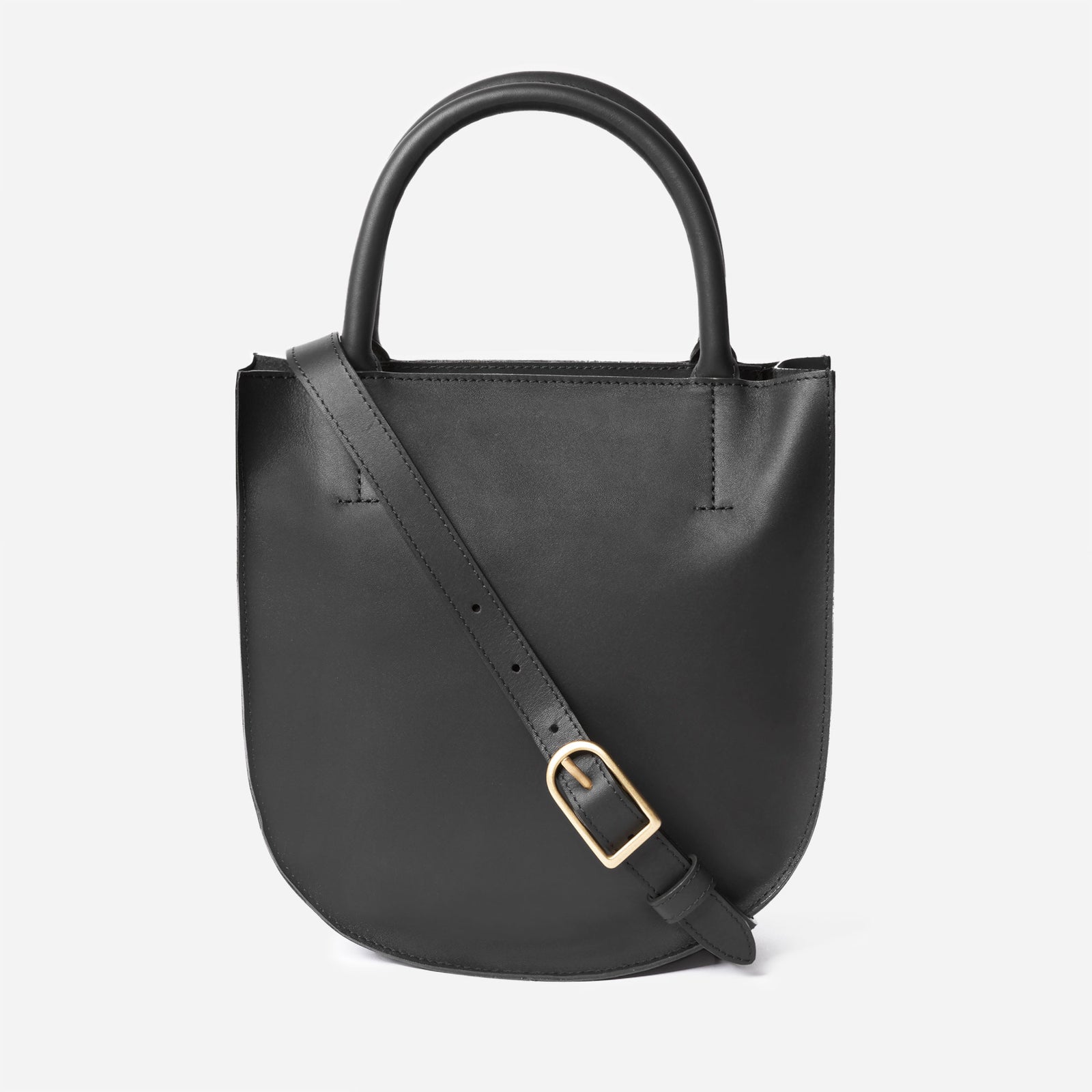 A black leather crossbody bag with an adjustable strap and solid brass hardware, viewed from the front. - Black