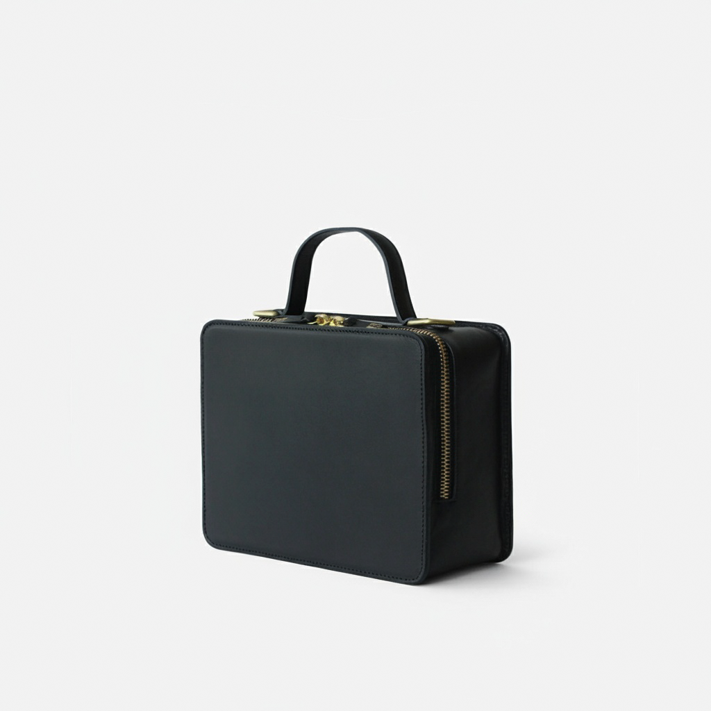 Black handbag with gold zipper on a light gray background - Black