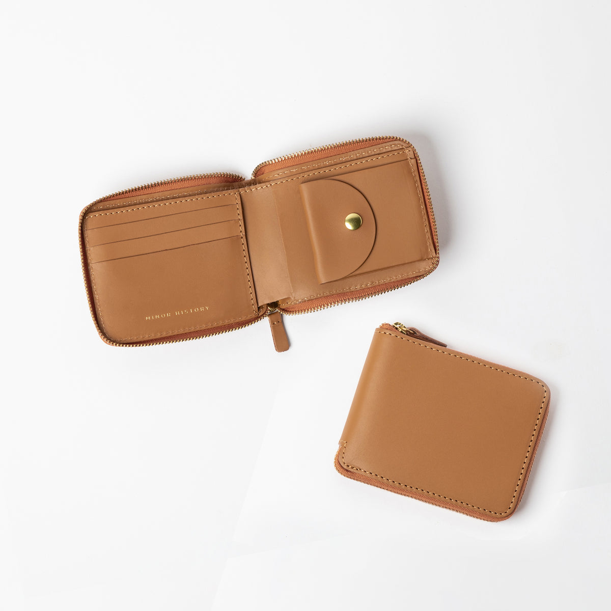 A tan leather wallet open to show the interior with card slots, a billfold, and a coin pouch; the wallet is displayed both open and closed. - Saddle