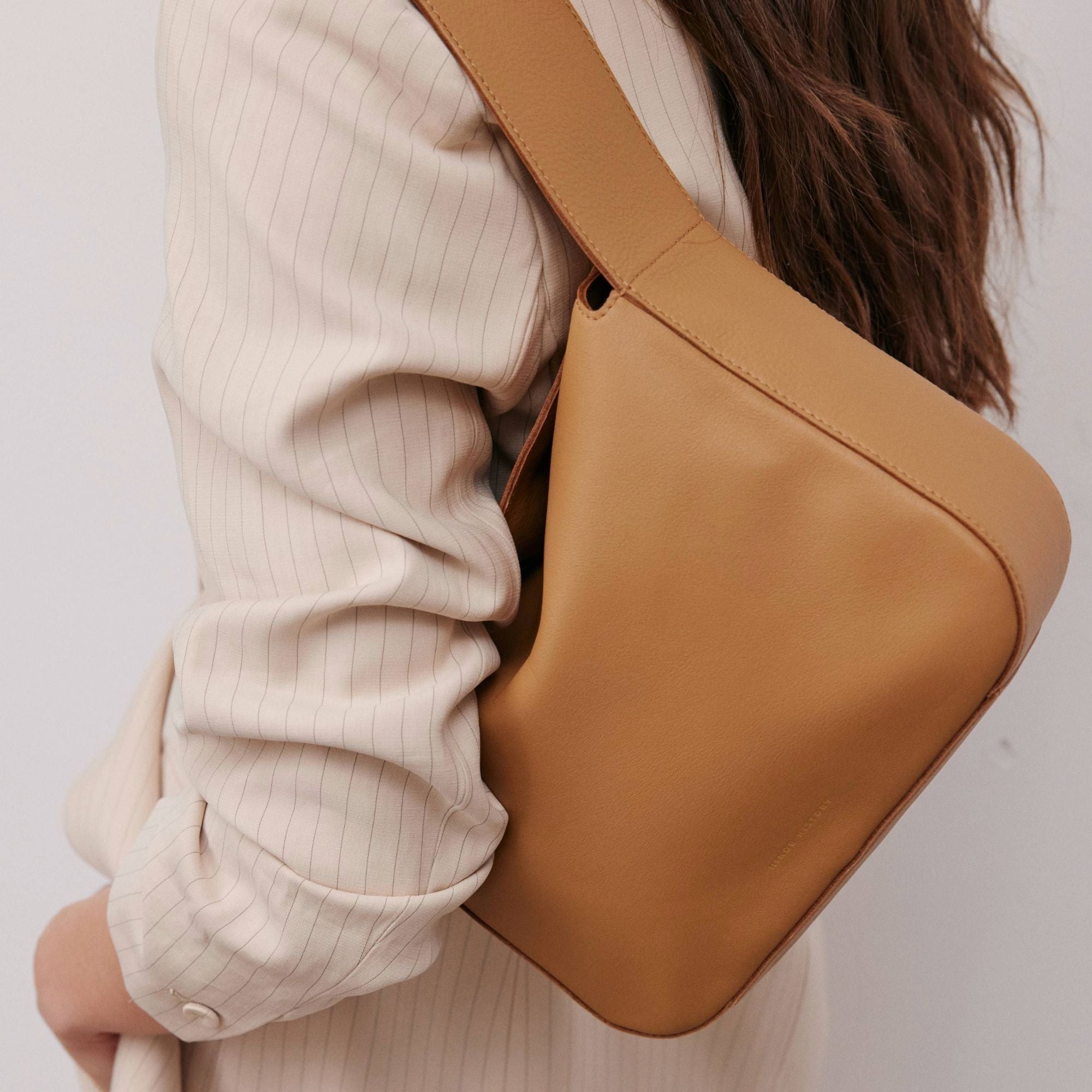 Frame Bag in luxury full-grain leather, styled as a shoulder bag with soft folds - Limelight
