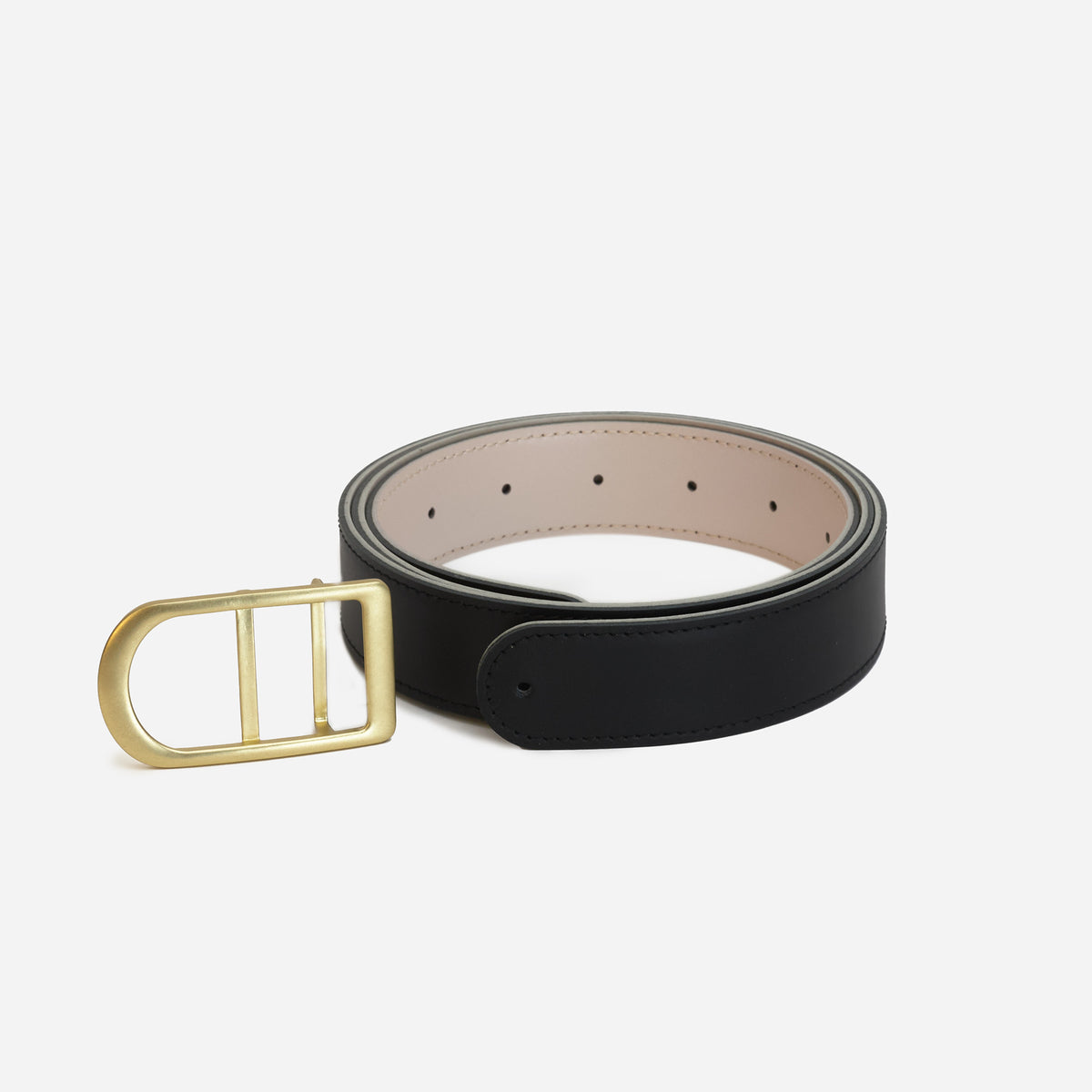 Gemini reversible belt in black and pearl full-grain leather with brass buckle, angled detail showing stitching and edge finish