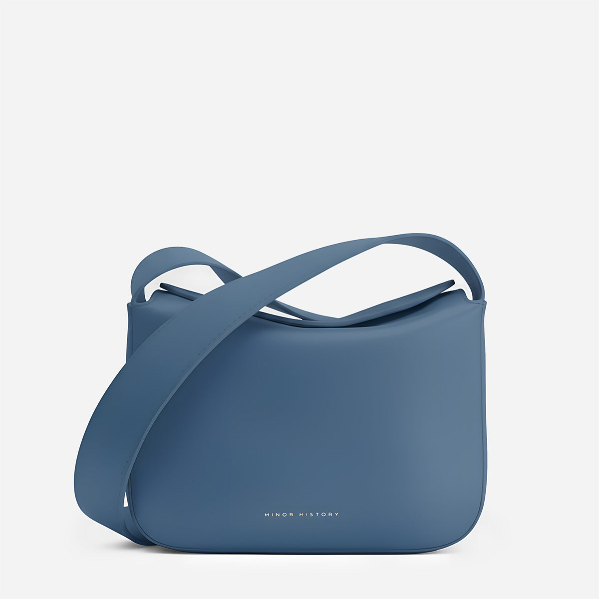Blue handbag with a strap on a light gray background  - Chambray