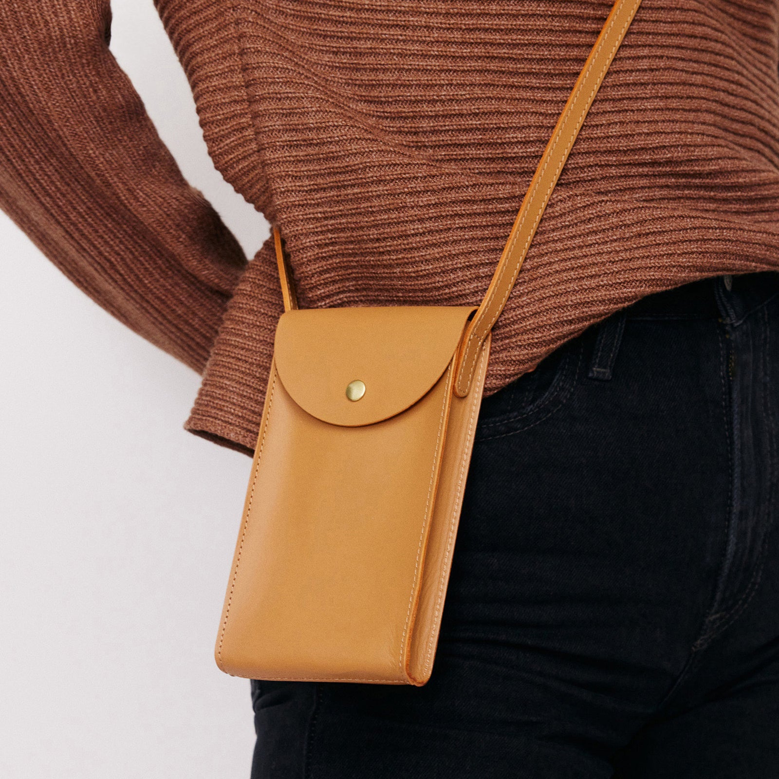 Mini Bandit crossbody bag in saddle brown full-grain leather, cropped view highlighting texture and stitching - Saddle