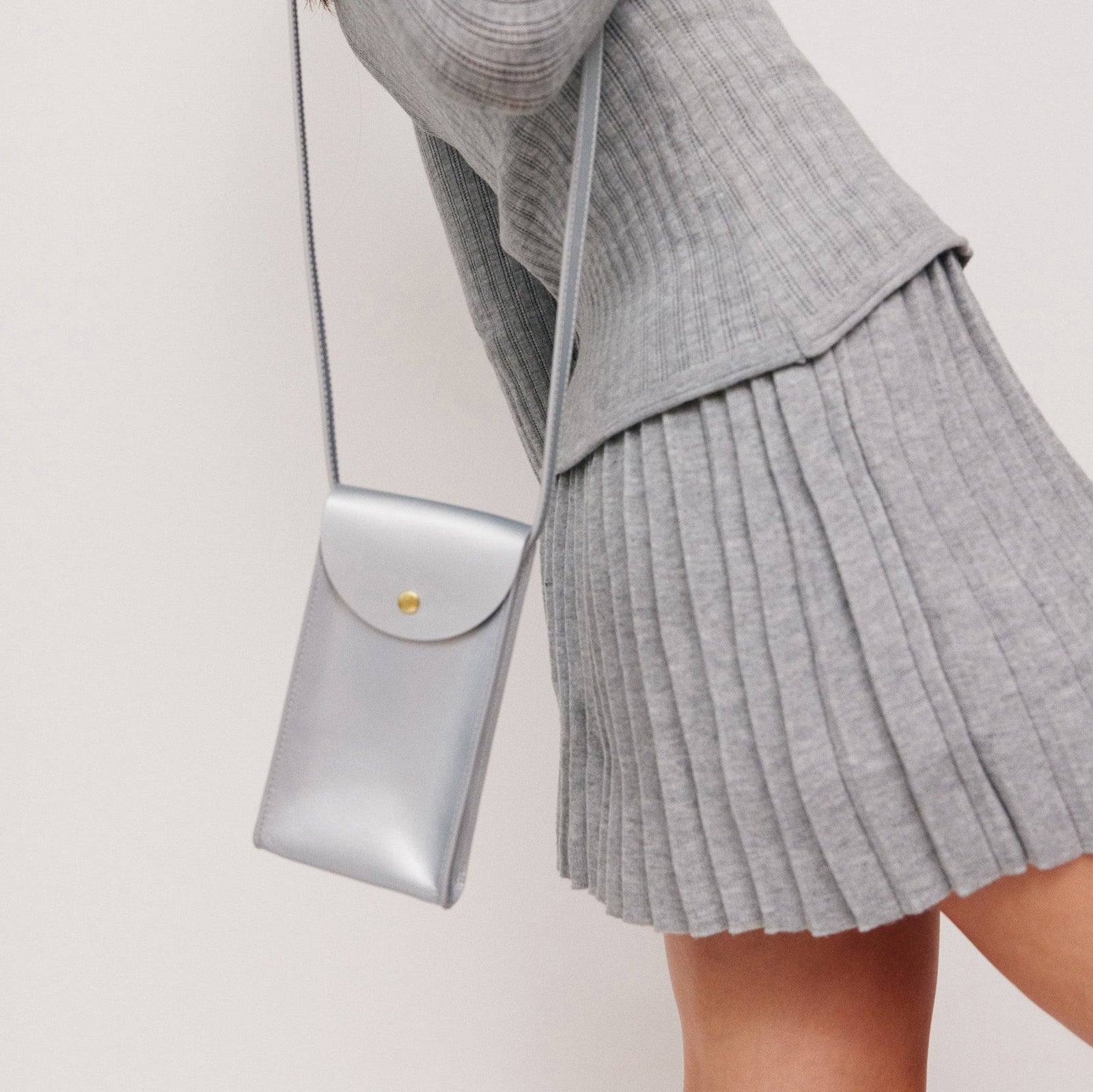 Mini Bandit crossbody bag in sterling silver full-grain leather, angled side view showing strap and shape  - Sterling