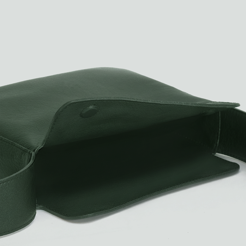 Green leather clutch bag on a light gray background  - Evergreen