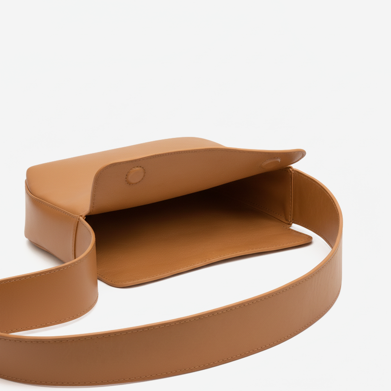 Tan leather belt with a buckle on a white background  - Saddle
