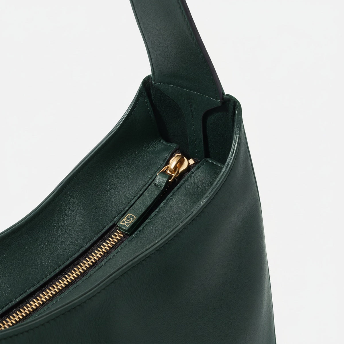 Black handbag with gold zipper on a light gray background  - Evergreen