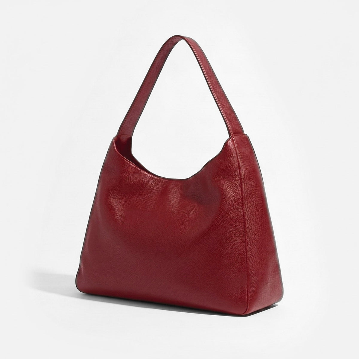 A burgundy pebbled leather hobo shoulder bag with a single top handle, photographed on a clean white background. -Cherry Cola