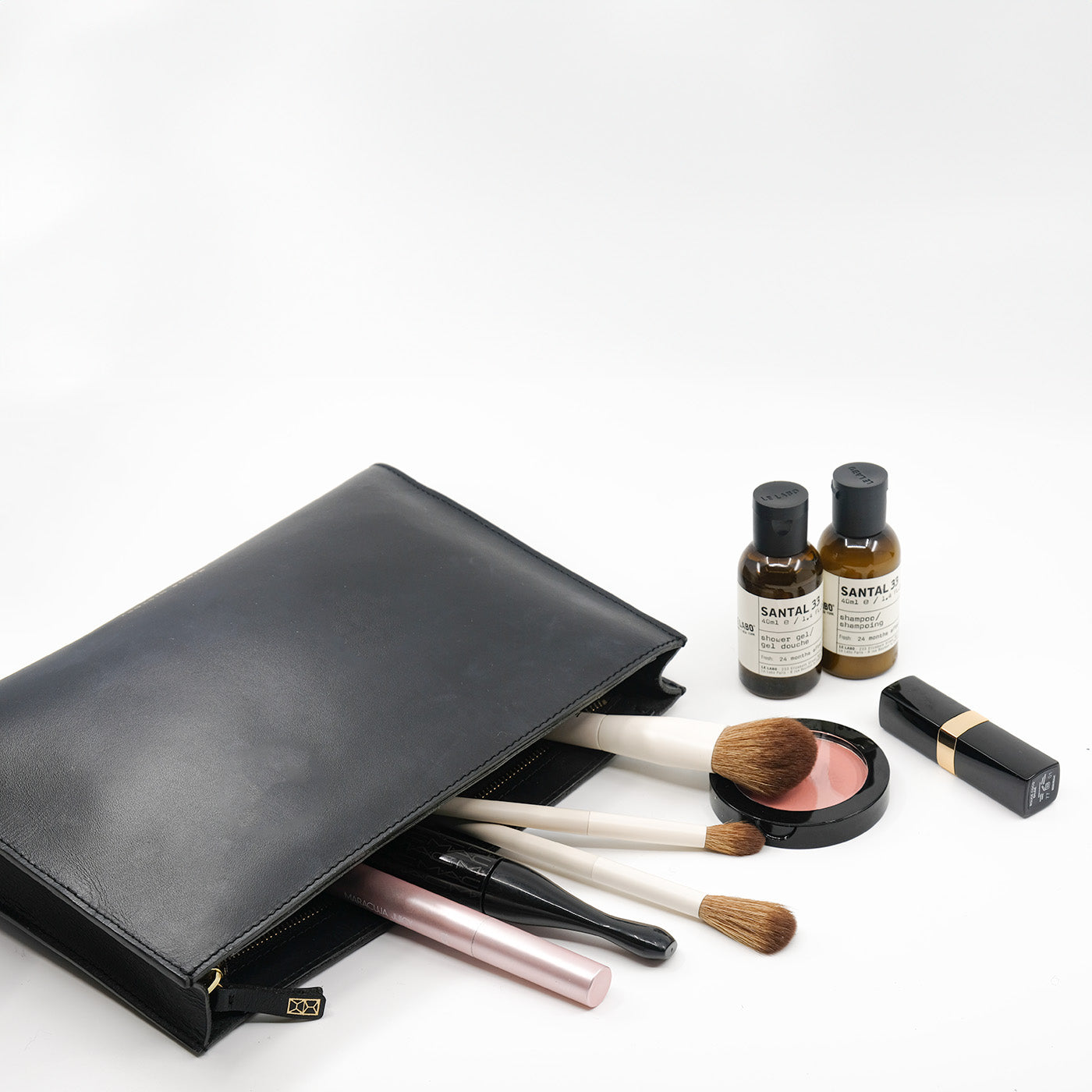 Black clutch bag with lipstick, phone, and keys on a white background - Black
