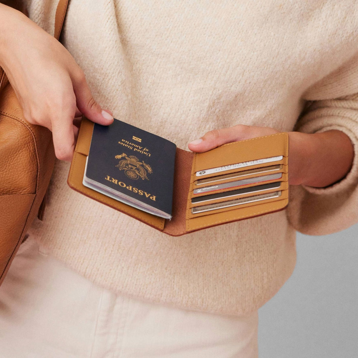 Atlas passport holder in luxury full-grain leather, front view in bright studio setting - Saddle