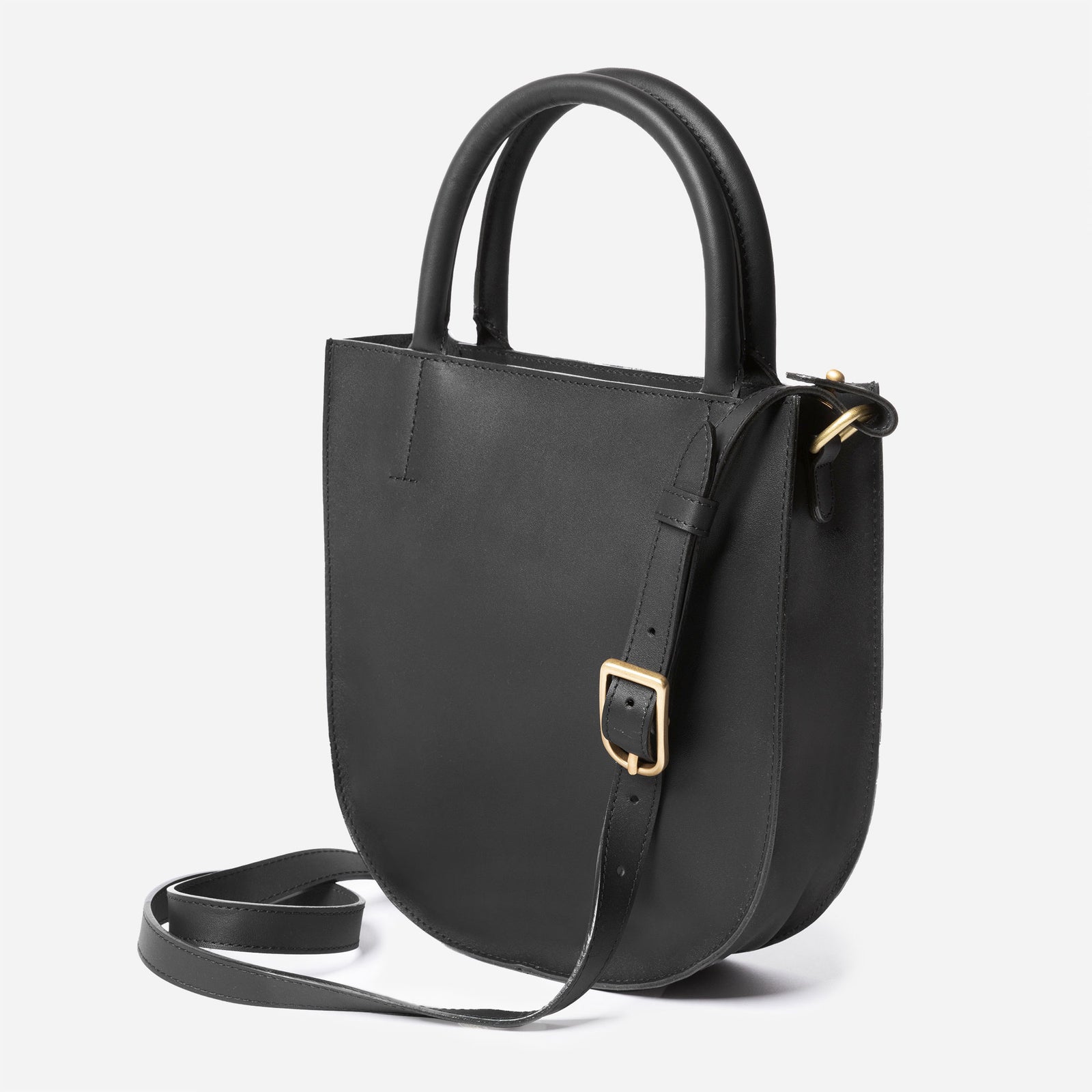 A black leather crossbody bag with an adjustable strap and solid brass hardware, viewed from the front. - Black