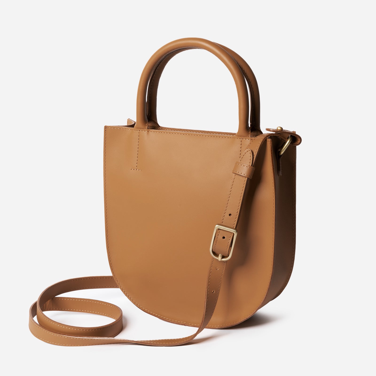 A black leather crossbody bag with an adjustable strap and solid brass hardware, viewed from the front. - Black